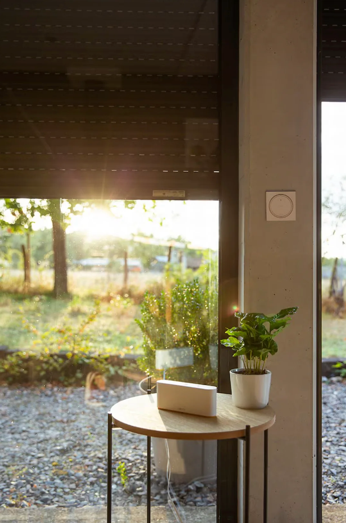 Maison avec jardin équipée de volets motorisés, télécommande murale Amy io et domotique Somfy TaHoma