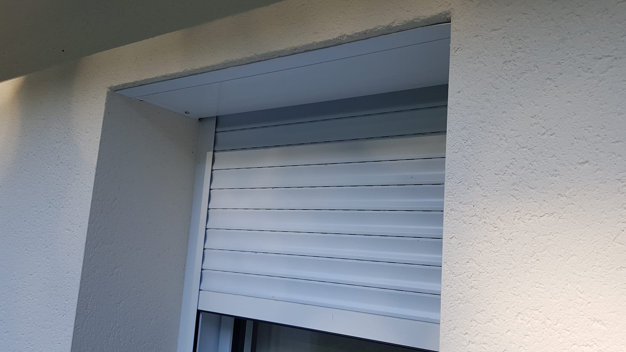 Volet roulant sur mesure en aluminium gris clair avec coffre pan coupé